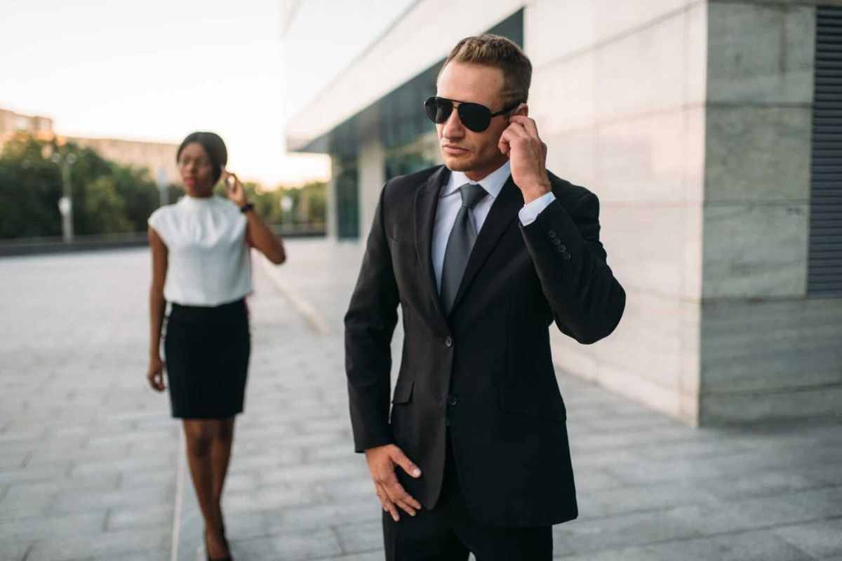 bodyguard-in-sunglasses-and-black-business-woman